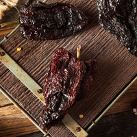 Dried chili peppers on a wooden surface.