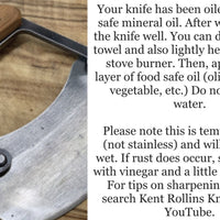 Close up of a curved meat cleaver.
