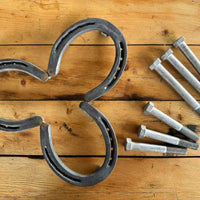 Horseshoe trivet with bolts on wood