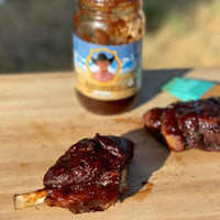 BBQ ribs and sauce on cutting board.
