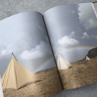 Open book with tents and a rainbow.