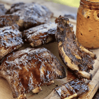 Glazed BBQ ribs on a wooden board.