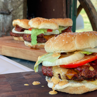 Close-up of a bacon cheeseburger with lettuce.