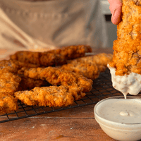 Fried chicken strips dipped in white sauce.