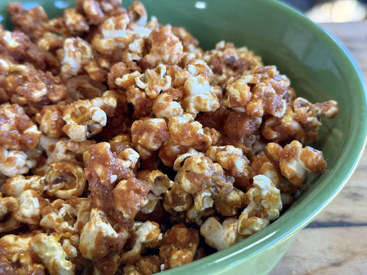 A green bowl filled with caramel popcorn.