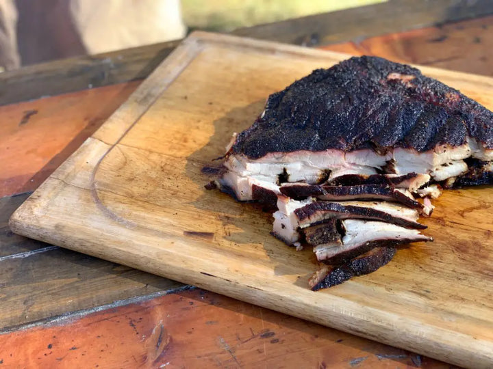 Smoked and sliced meat on a cutting board.