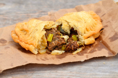 A wooden table with two halves of a meat pie 
