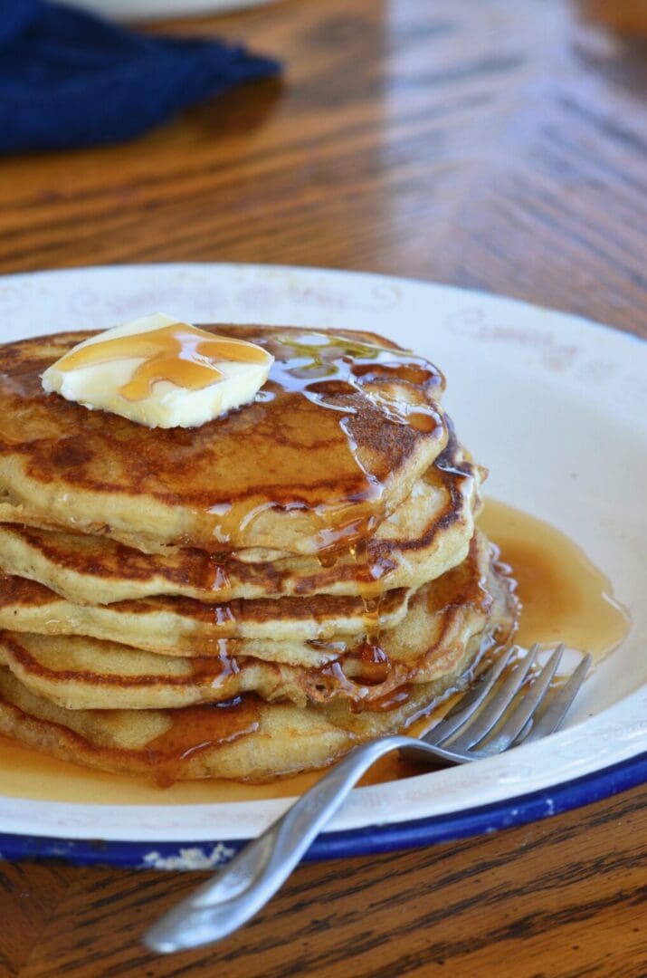 Buttery pancakes with syrup and a fork.