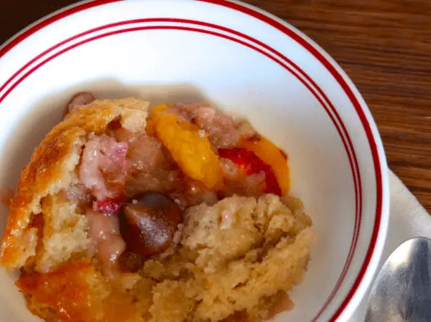 Peach cobbler in a white bowl.