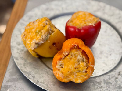 Three bell peppers stuffed with leftover holiday stuffing on a plate