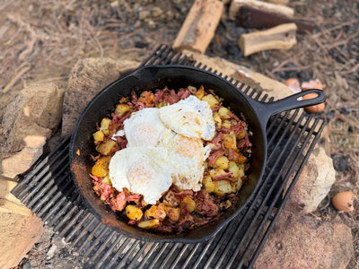 Corned Beef Hash in a cast iron skillet over a campfire