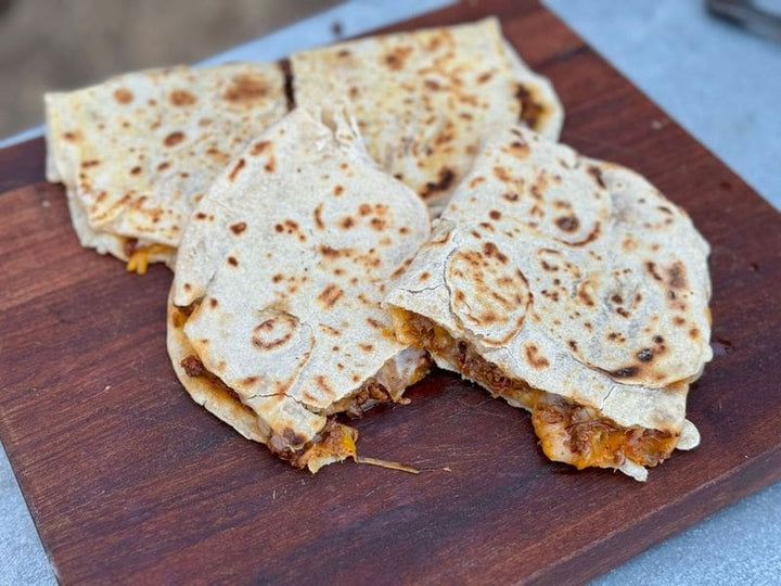 Delicious quesadillas on a wooden board.