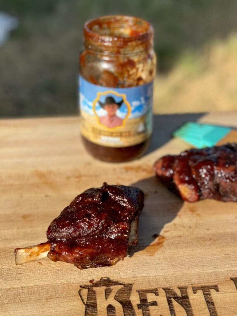 BBQ ribs and sauce on cutting board.