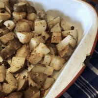 Seasoned potato wedges in a baking dish.