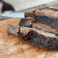 Grilled beef short ribs on a cutting board.