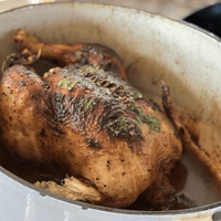 Roasted chicken with herbs in a pot.