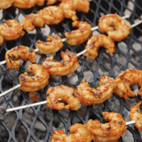 Grilled shrimp skewers on a grill grate.