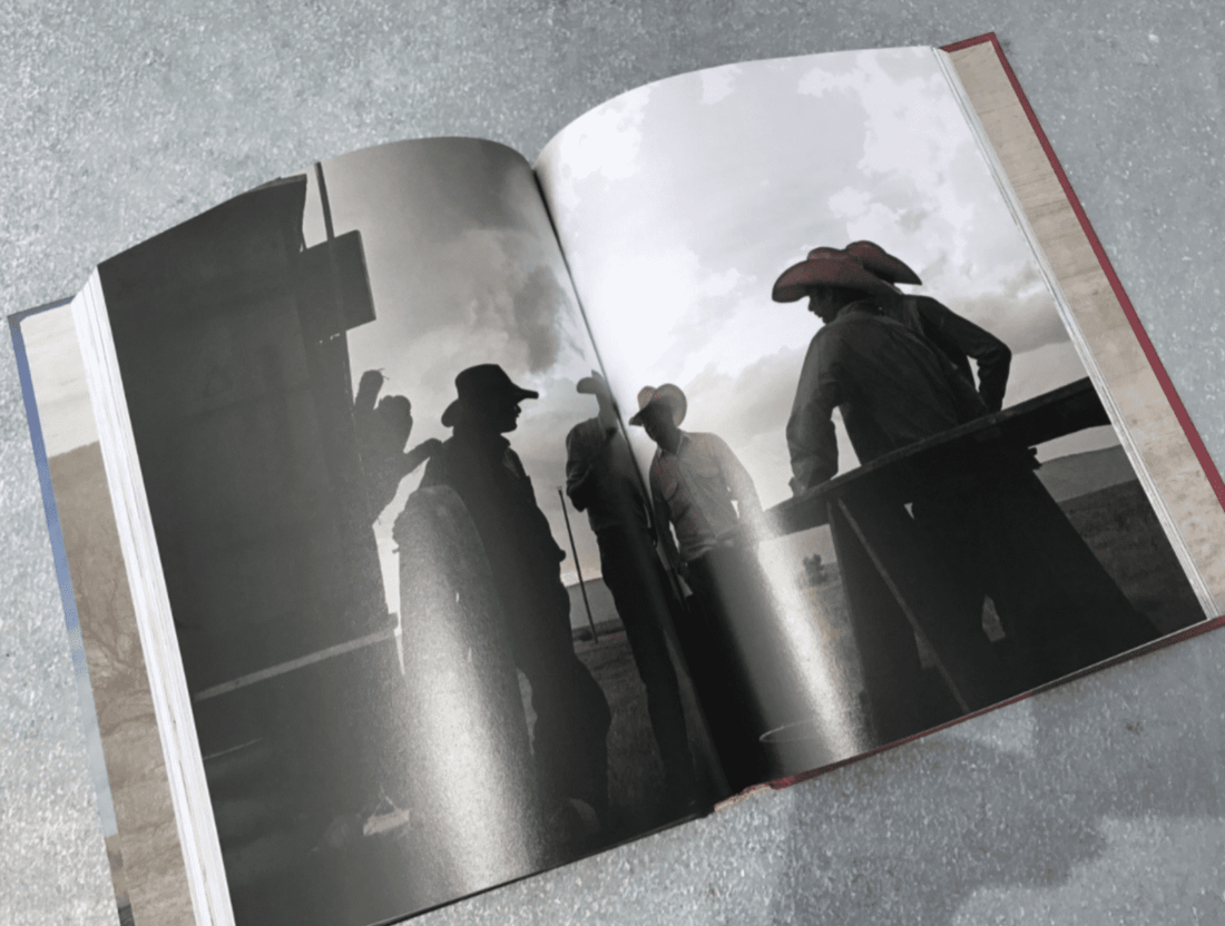 Open book with cowboys in silhouette.