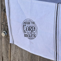 White tea towel with "Praise the Lord and Pass the Biscuits" saying.