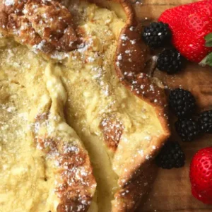 Dutch baby pancake with powdered sugar and fruit.