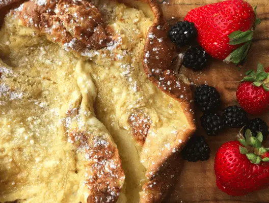 Dutch baby pancake with powdered sugar and fruit.