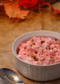 A bowl of cranberry salad with nuts.