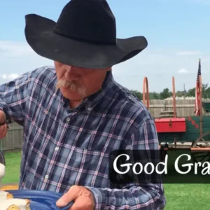 Man in cowboy hat pours gravy on food.