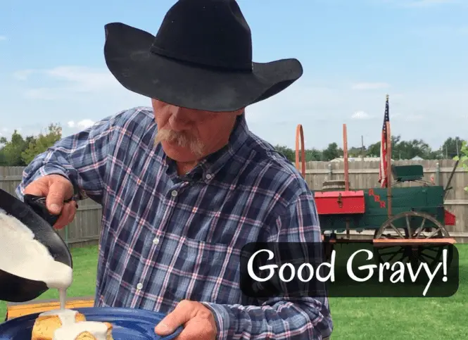 Man in cowboy hat pours gravy on food.