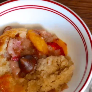 Peach cobbler in a white bowl.