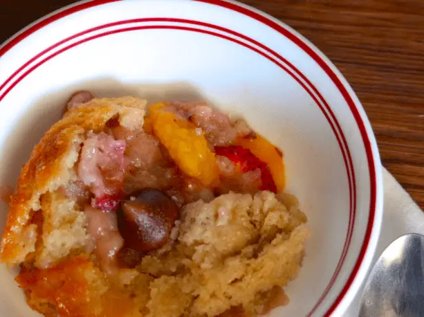 Peach cobbler in a white bowl.