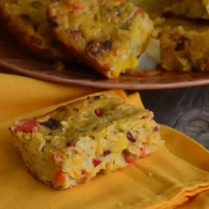 Cornbread with red peppers on a napkin.