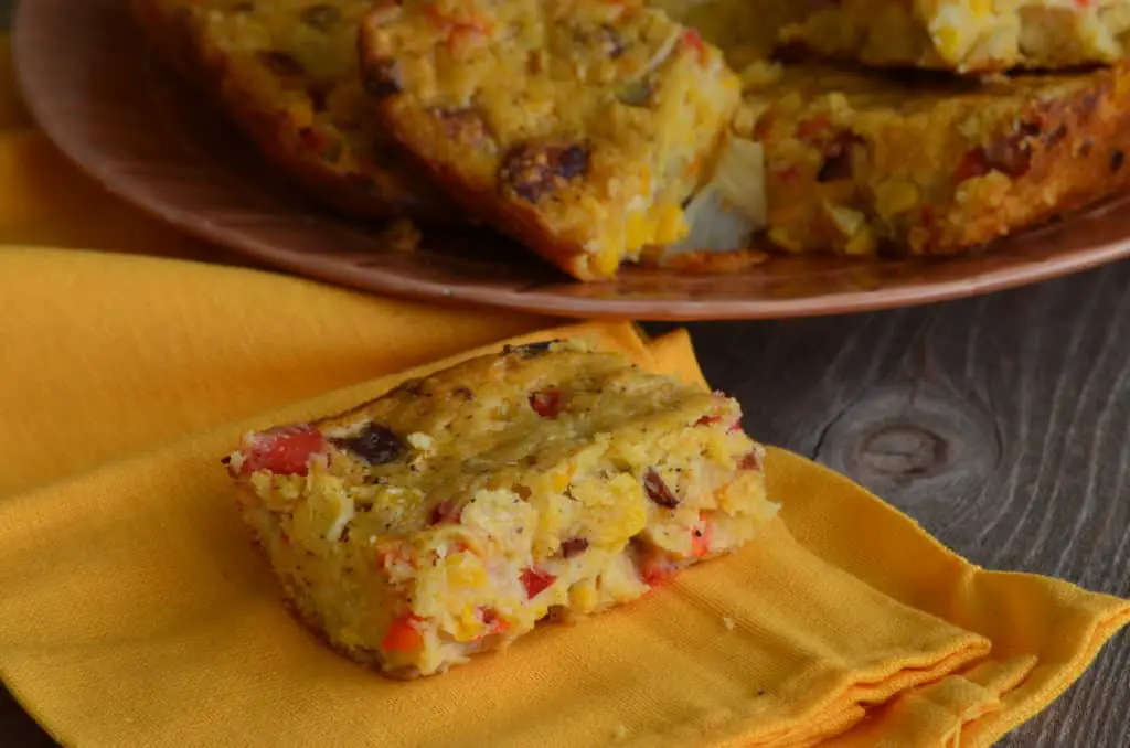 Cornbread with red peppers on a napkin.