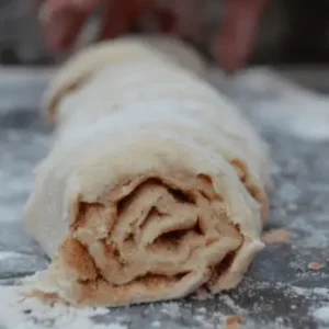 A close-up of a cinnamon roll dough.