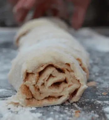 A close-up of a cinnamon roll dough.