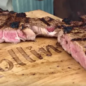 Grilled steak on a wooden cutting board.