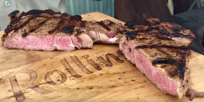 Grilled steak on a wooden cutting board.