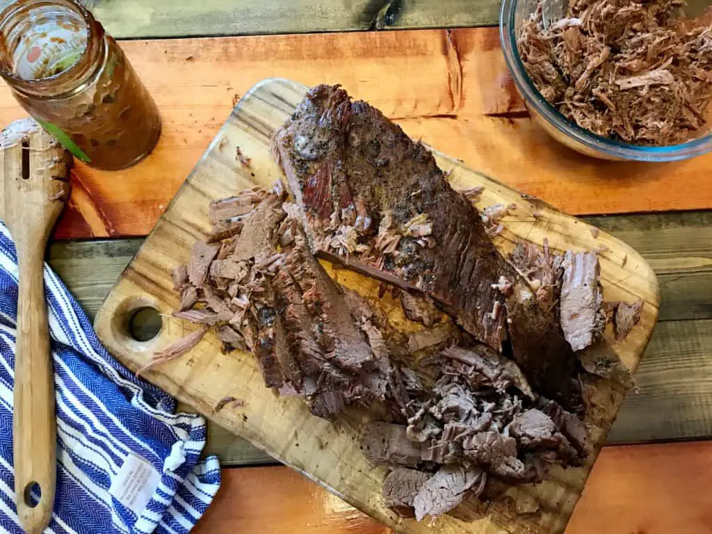 Shredded beef on a cutting board.