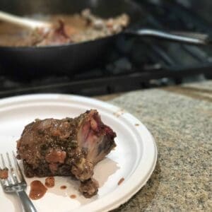 A plate with a fork and a meat dish.