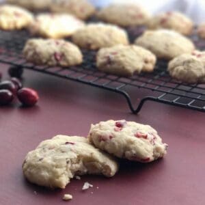 Two cranberry cookies on a red table.