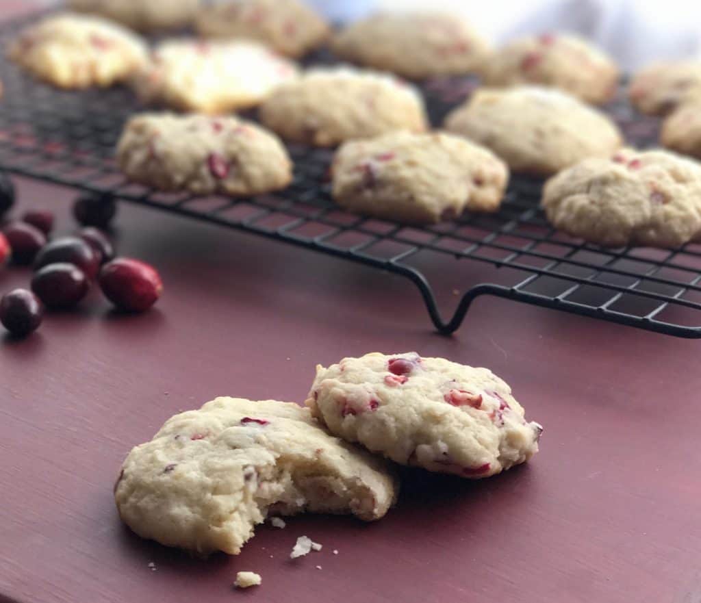 Two cranberry cookies on a red table.