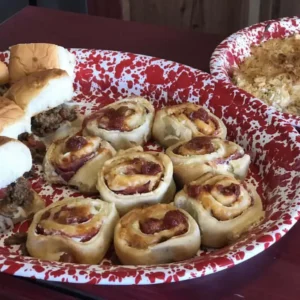 Pizza rolls and sliders on red tray.