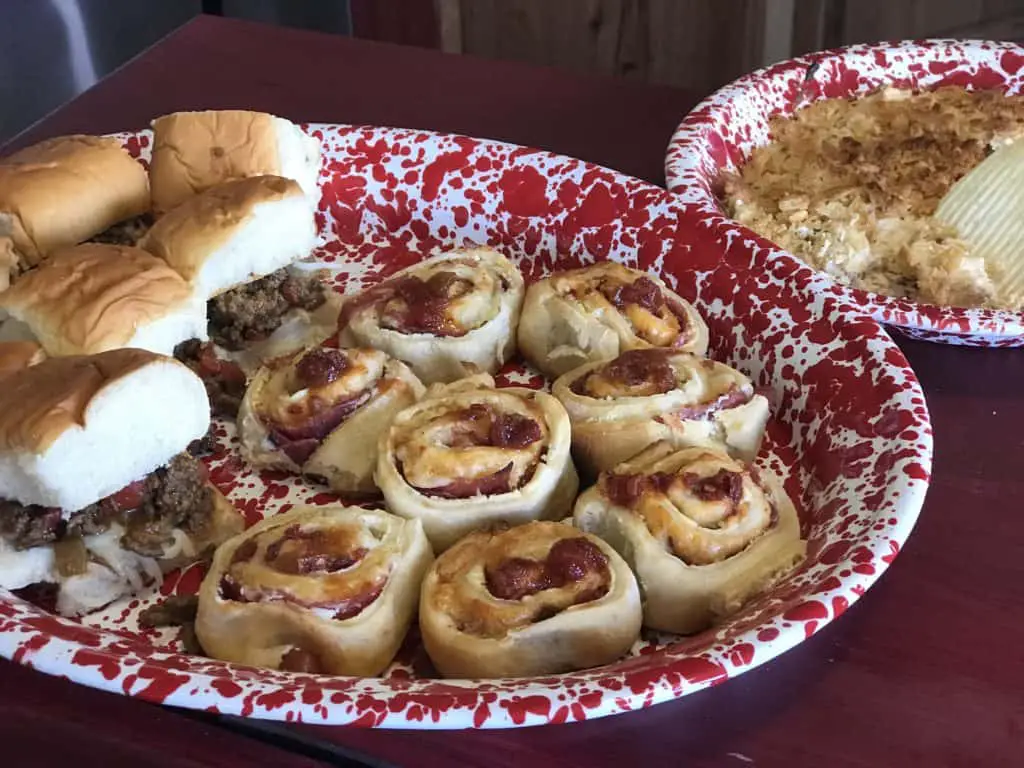 Pizza rolls and sliders on red tray.