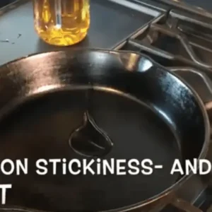 Oil being poured into a cast iron pan.