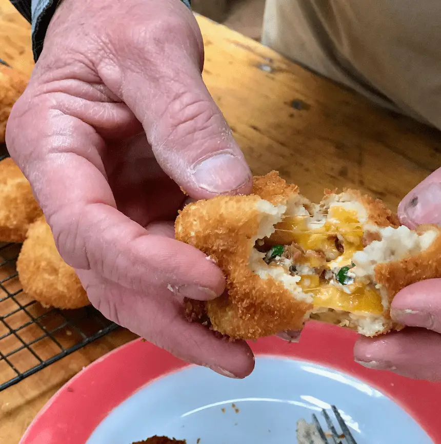 Cheesy potato croquettes with a bite taken out.