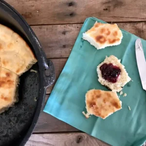 Buttermilk biscuits with jam on a blue napkin.