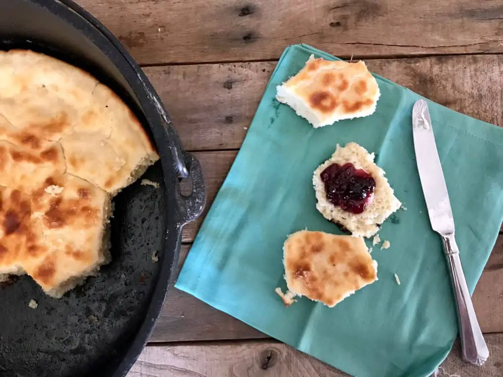 Buttermilk biscuits with jam on a blue napkin.