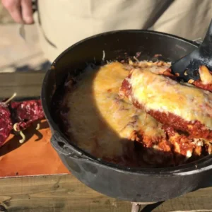 Cheesy enchiladas in a cast iron pot.