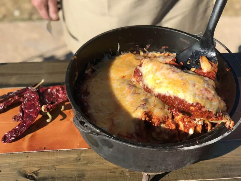 Cheesy enchiladas in a cast iron pot.