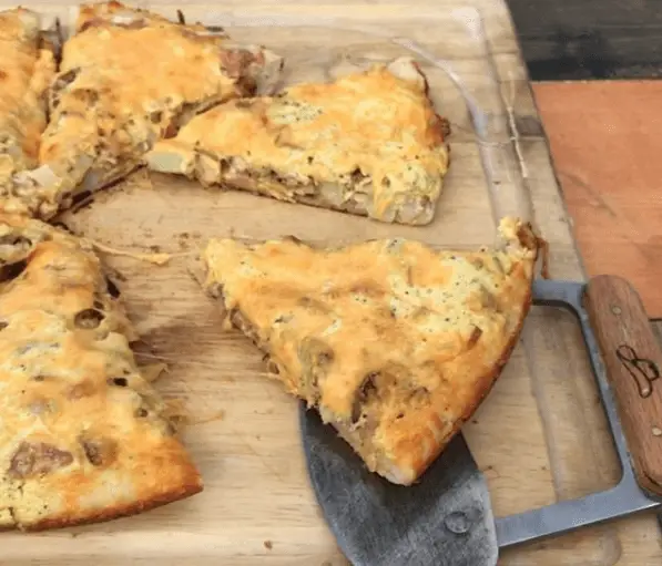 Cheesy pizza slices on a cutting board.