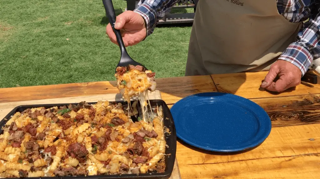 Cheesy loaded fries being served on a plate.